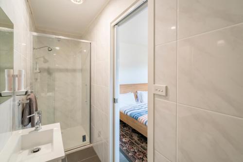 a bathroom with a shower and a sink and a mirror at Tarraleah Estate in Tarraleah
