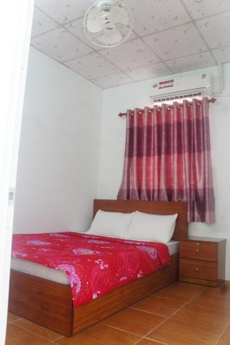 a bedroom with a bed with a red blanket at BangBang Motel in Can Tho