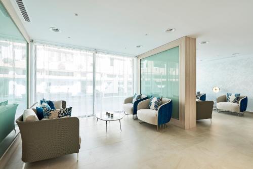 a living room with couches and chairs and windows at Eurostars Ibiza in Ibiza Town