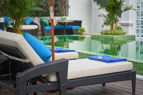 two chairs sitting in front of a swimming pool at Manoir Des Arts Hotel in Hai Phong