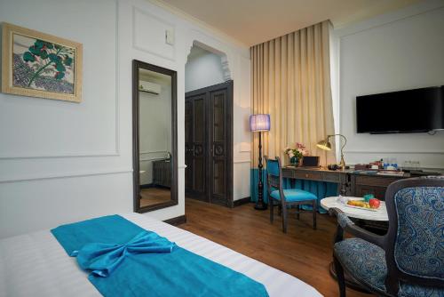 a hotel room with a bed and a desk with a computer at Manoir Des Arts Hotel in Hai Phong
