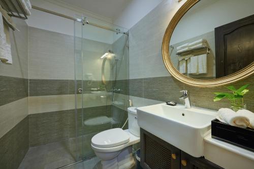 a bathroom with a toilet and a sink and a mirror at Manoir Des Arts Hotel in Hai Phong