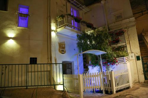 a white building with purple windows and a fence at The Bridge Suites in Gravina in Puglia