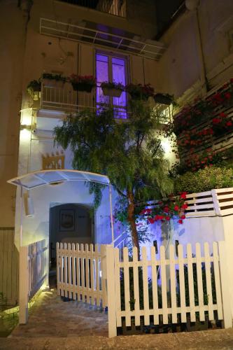 a white fence in front of a house with a tree at The Bridge Suites in Gravina in Puglia