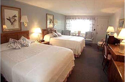 a hotel room with two beds and a desk at Mount Battie Inn in Lincolnville