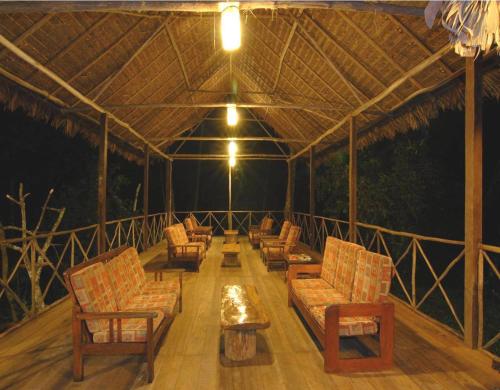 a screened in porch with chairs and a table at Wasai Tambopata Lodge in Tambopata