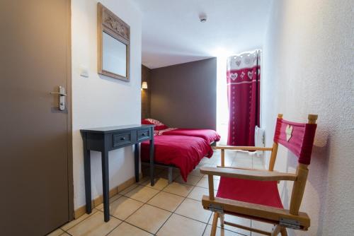 a bedroom with a bed and a table and a chair at Gîte La Maisonnée in Sazos