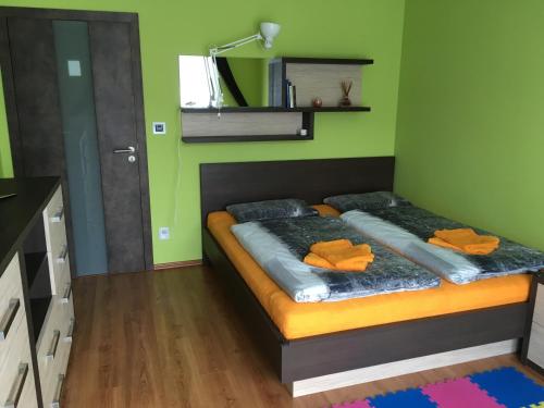スピンドレルフ・ムリンにあるHoliday Apartment Spindleruv Mlynのベッドルーム1室(オレンジ色の枕が付いたベッド1台付)