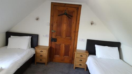 a room with two beds and a wooden door at Dunskaith Villa in Inverness