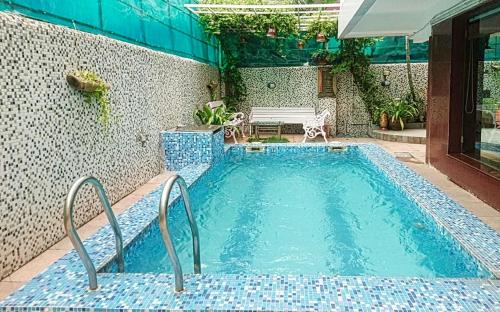 a swimming pool with a bench next to a building at Tatvam Residency in Kolkata