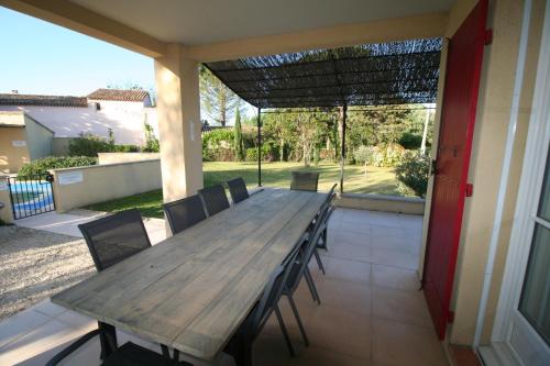 a wooden table and chairs on a patio at 225 Chemin des Joncs in Saint-Pierre-de-Vassols