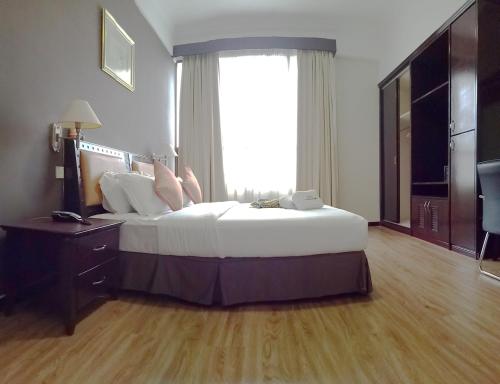 a bedroom with a large bed and a large window at Hotel Langkasuka Langkawi in Kuah