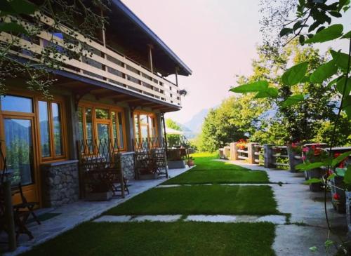 a house with a grass yard next to a building at Agriturismo La Selvaggia in Mandello del Lario