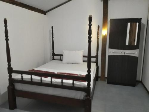 a bedroom with a bed and a mirror at Banyu Homestay in Banyuwangi