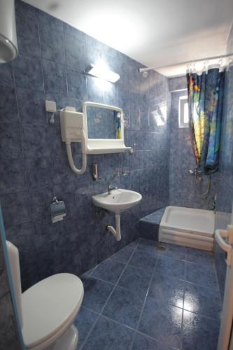 a bathroom with a sink and a toilet and a tub at Apartments Kruna Jovanović in Sutomore