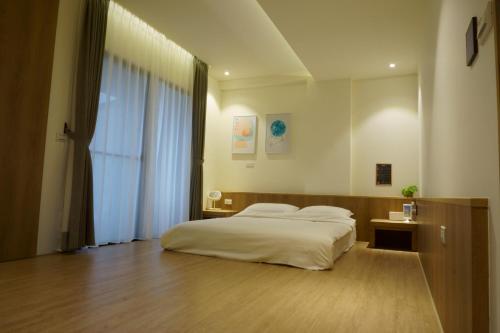 a bedroom with a bed and a large window at Ecology River in Dongshan