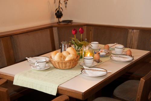 a table with a basket of bread and flowers on it at Pension Post - Sistrans in Innsbruck