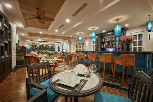 a restaurant with tables and chairs and a bar at Manoir Des Arts Hotel in Hai Phong