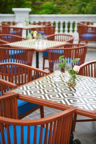 a group of tables and chairs with flowers on them at Manoir Des Arts Hotel in Hai Phong