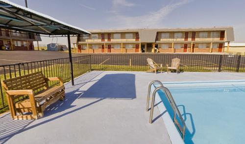 a swimming pool with two chairs and a building at Americas Best Value Inn Wall in Wall