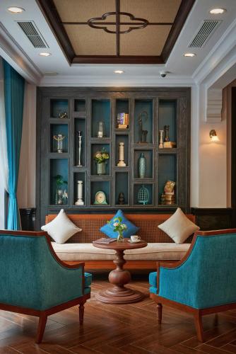 a living room with a table and two chairs at Manoir Des Arts Hotel in Hai Phong