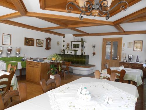 a room with tables and chairs and a kitchen at Familienbauernhof Strassbauer in Steinakirchen am Forst