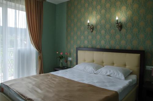 a bedroom with a bed with green walls and a window at Triumph in Skhidnitsa