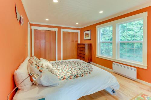 a bedroom with orange walls and a bed at Shore Thing Retreat in Eastsound