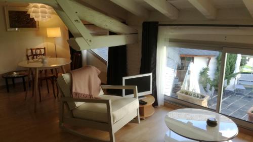 a living room with a chair and a table at La Maison Carolane in Latour-de-Carol