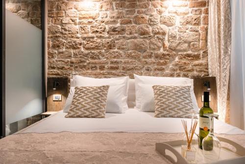 - une chambre avec un lit et un mur en briques dans l'établissement Ziggy Star in Diocletian Palace, à Split