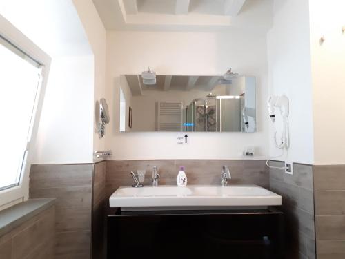 a bathroom with a white sink and a mirror at Casadina in Monte Isola