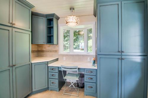 una cocina con armarios azules y una lámpara de araña en Sills Bluff Sunset Vista en Clinton