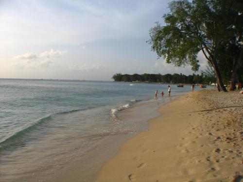 a group of people walking on the beach at Condominium 220 in Saint James