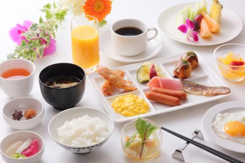 a white table topped with plates of food and drinks at Osaka Tokyu REI Hotel in Osaka