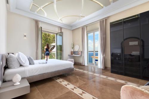 a woman standing in a bedroom with a large bed at Sorrento Dream in Sorrento