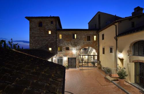 a large stone building with an archway in a courtyard at Borgo Antico Casalbosco Holiday Home & Winery in Santomato 