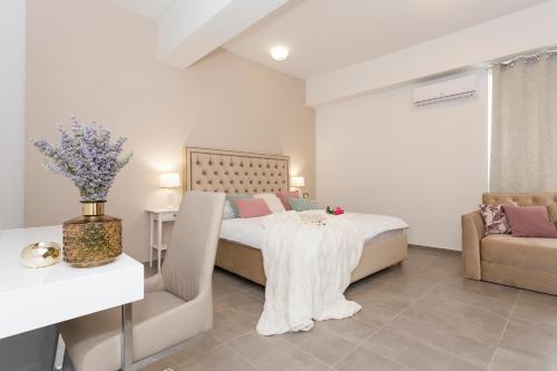 een slaapkamer met een bed, een tafel en een bank bij Luxury Rooms Saint Jacob in Trogir