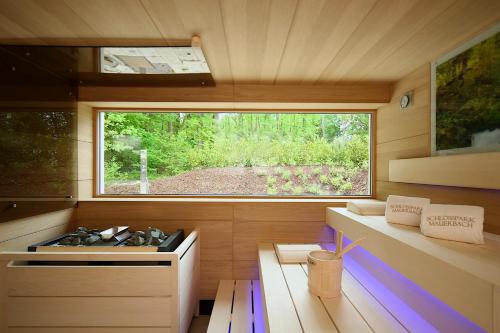 a room with a sauna with a window and a bench at Schlosspark Mauerbach - Adults only in Mauerbach