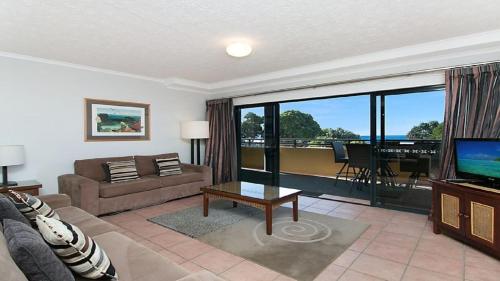 a living room with a couch and a television at Heritage Pines Apartment by Kingscliff Accommodation in Kingscliff
