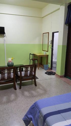 a room with a table and a mirror at Sataya Apartment in Maha Sarakham