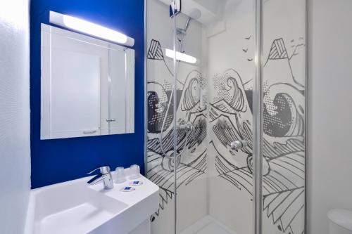 ein Bad mit einer Dusche, einem Waschbecken und einem Spiegel in der Unterkunft Ibis budget Chambéry Centre Ville in Chambéry