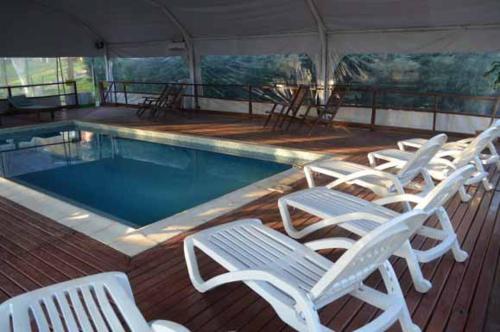 a group of white chairs next to a swimming pool at Terrazas de Colón in Colón