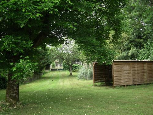 a yard with a fence and a tree at Maison de Fortitude Chambres d'hotes in Salviac