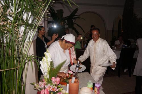 un hombre sosteniendo un plato delante de otro hombre en Riad Shanima SPA Marrakech en Marrakech