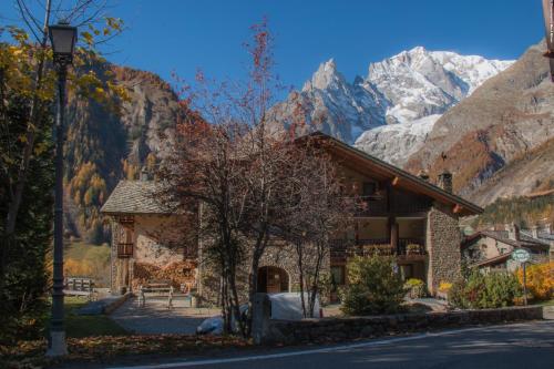 a building with a mountain in the background at Auberge de La Maison in Courmayeur
