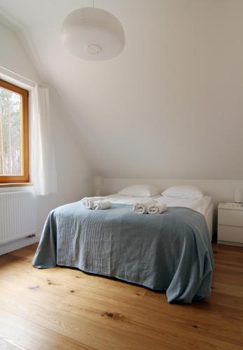 a white bedroom with a bed with a blue blanket at Osada Osjaków in Osjaków
