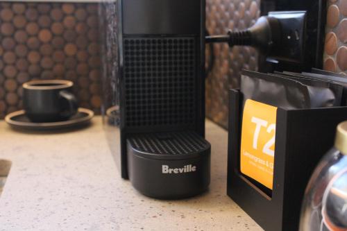 a black coffee maker sitting on a counter with a cup at The Woods Pokolbin in Pokolbin