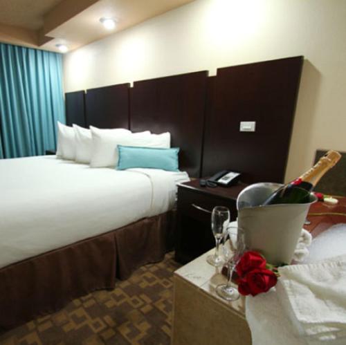 a hotel room with two beds and a bottle of champagne at Wyndham Garden Midland in Midland