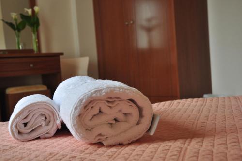 2 asciugamani laminati posti sopra un letto di Ostria Hotel a Paleocastro (Palekastron)