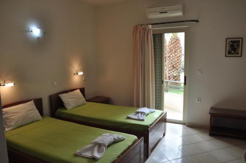 2 camas en una habitación con ventana en Ostria Hotel en Palekastron